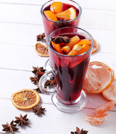 Bild vom Glühwein-Check: Ein Glas mit Glühwein und Orangen und Mandarinen